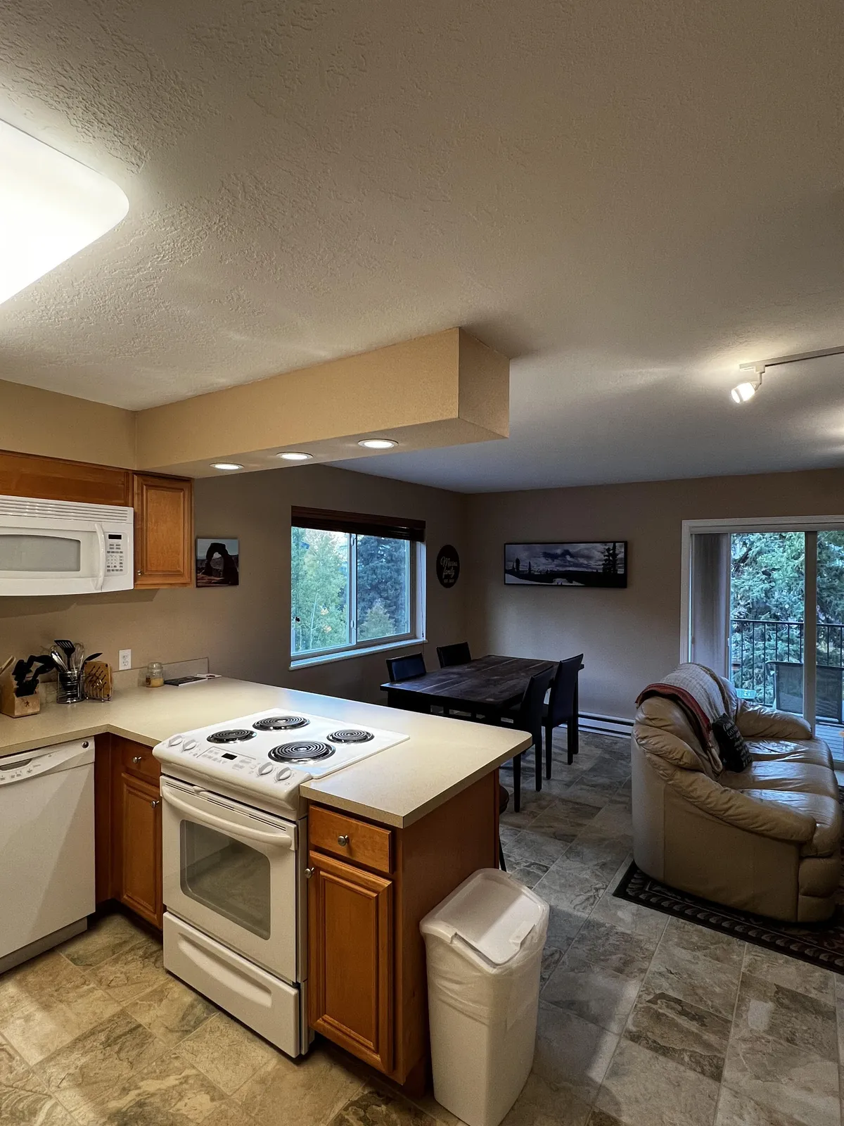 A spacious kitchen area seamlessly connects to a welcoming dining table and seating area. The kitchen island serves as a social hub, while the dining table is set for communal meals, echoing the spirit of laughter-filled family feasts.